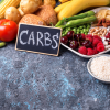 Image of fruits, bread and sign that reads 'CARBS'